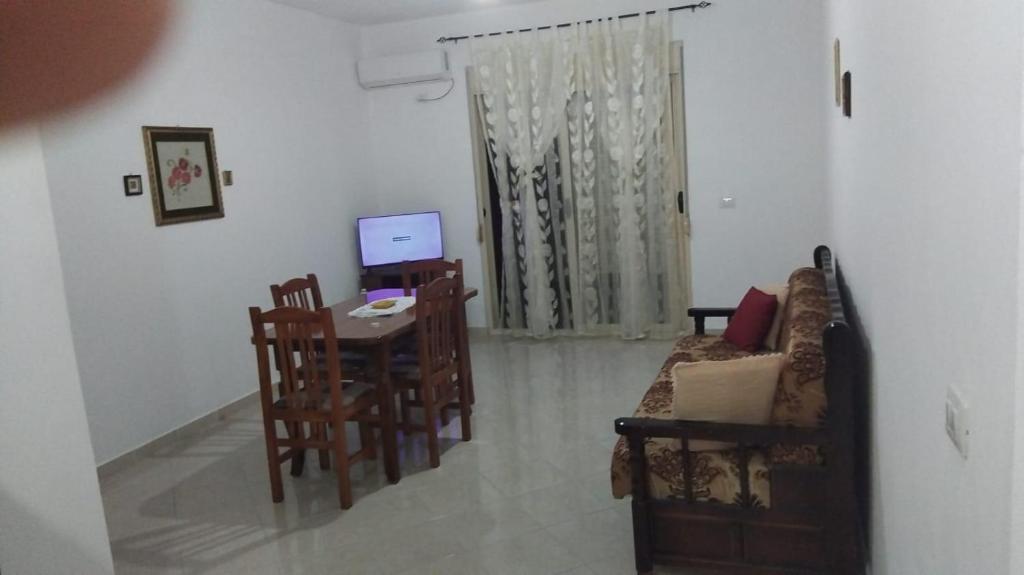 a living room with a couch and a table with a computer at Casa vacanza in Vlorë