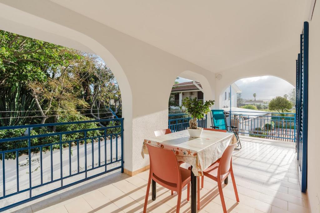 a dining room with a table and chairs on a balcony at Venti Del Mare in Trappeto