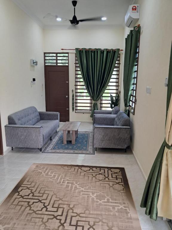 a living room with two couches and a coffee table at Homestay Kubang Kerian, Kota Bharu in Kota Bharu
