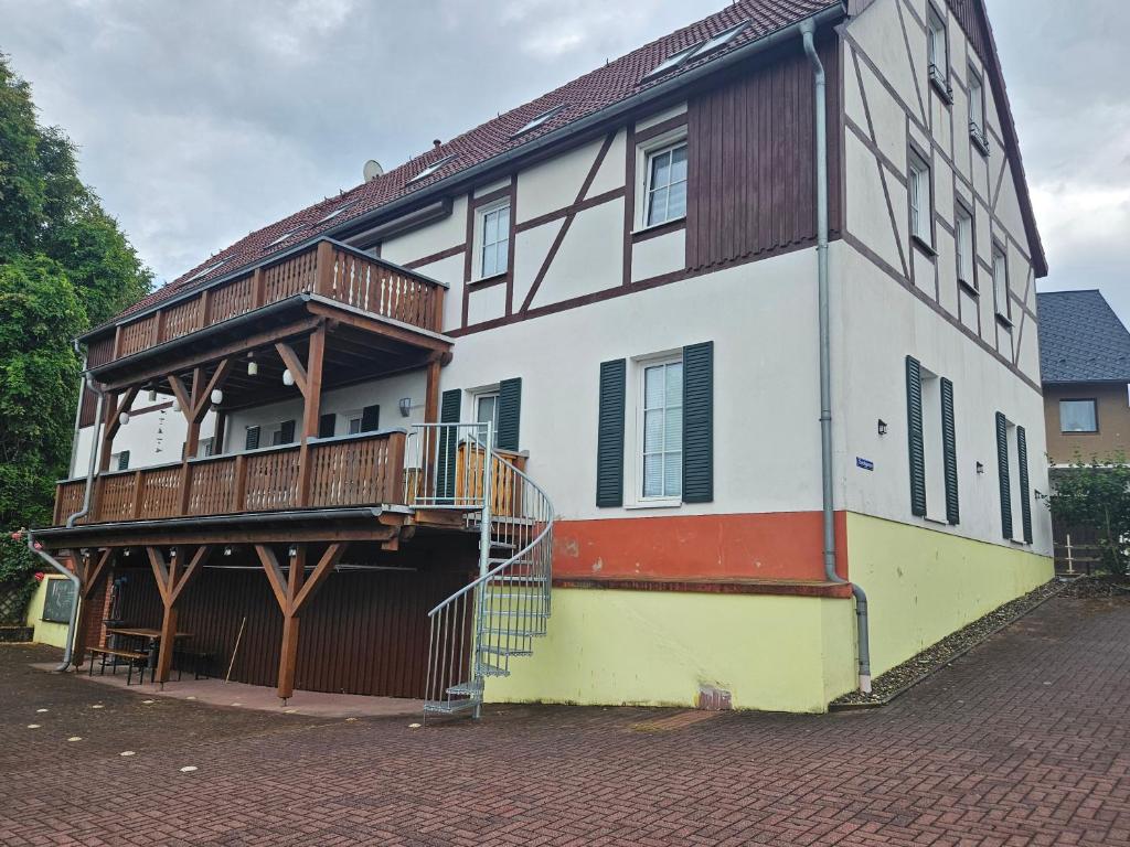 a large house with a balcony and a brick street at Ferienhof An der Weide in Kurort Gohrisch