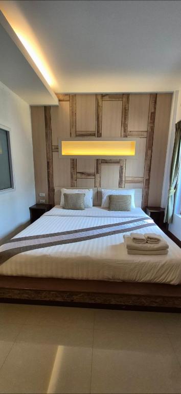a bedroom with a large bed with a light above it at The Peace Tara House in Ko Lanta