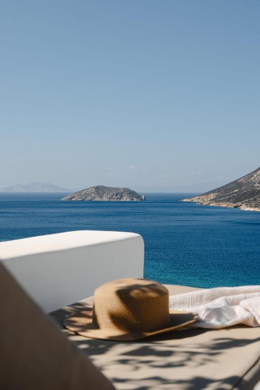 a hat sitting on a table next to the ocean at PhosAlos Apartments in Aegiali