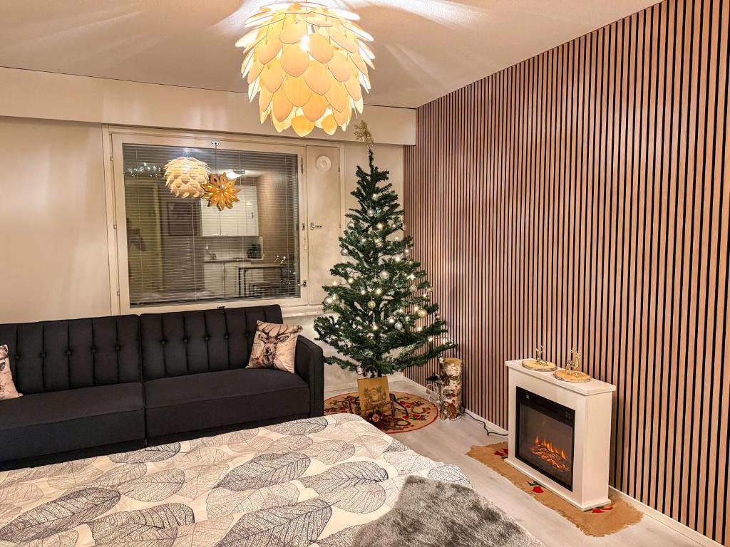 a living room with a christmas tree and a couch at Warm Wooden Home in Rovaniemi in Rovaniemi