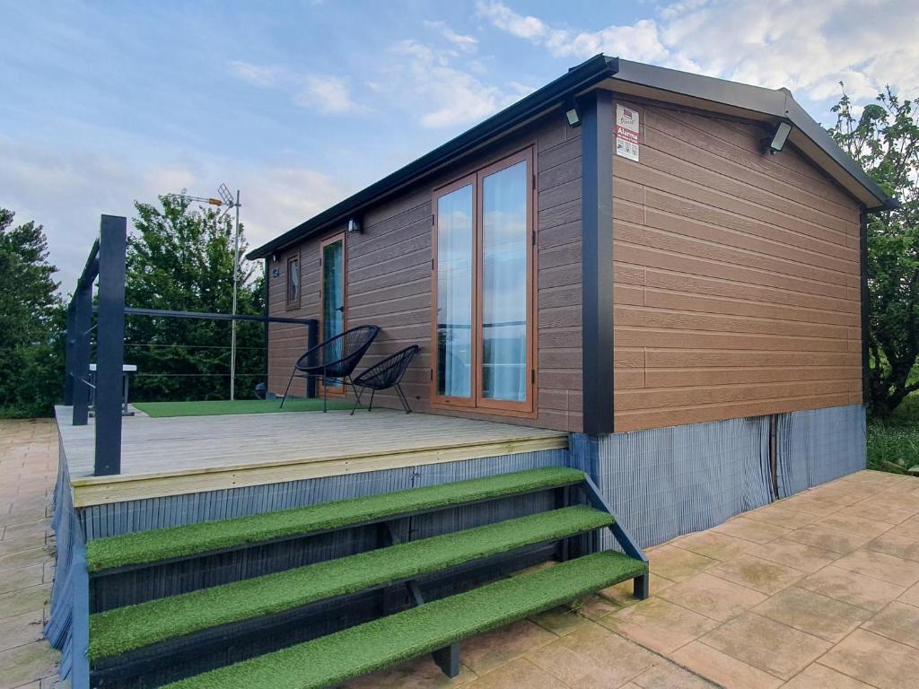 une petite maison avec une terrasse et une chaise dans l'établissement Apartamentos via street 3000, à Hinojedo