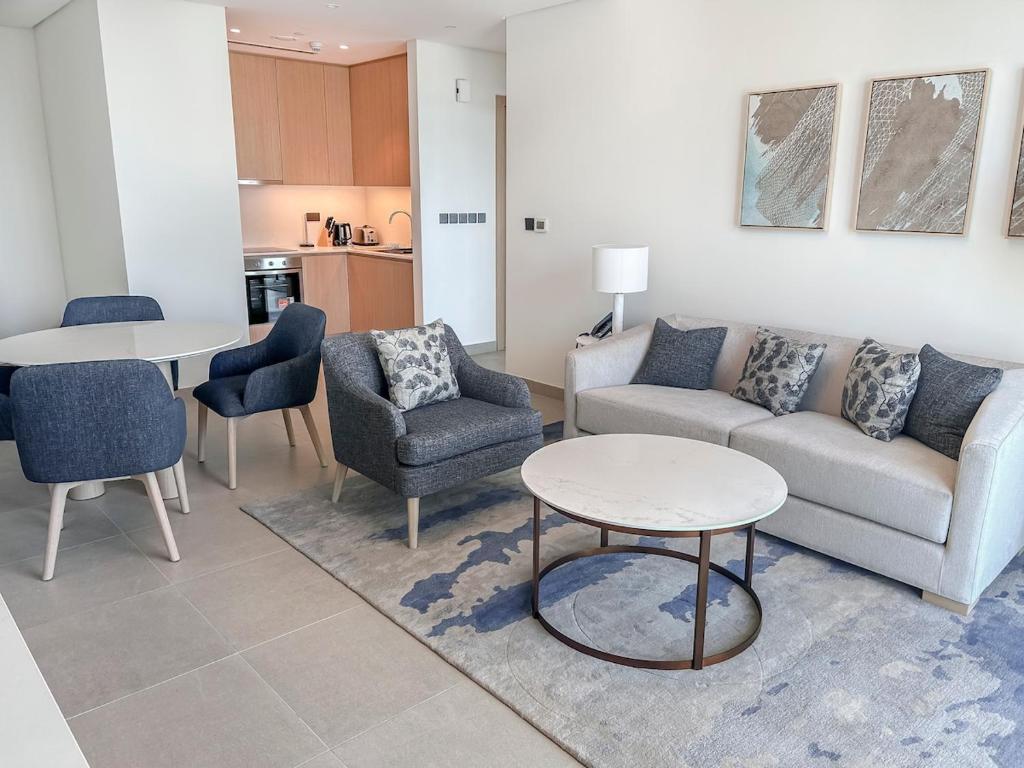 een woonkamer met een bank, stoelen en een tafel bij Marrasi Vista by the address in Muharraq
