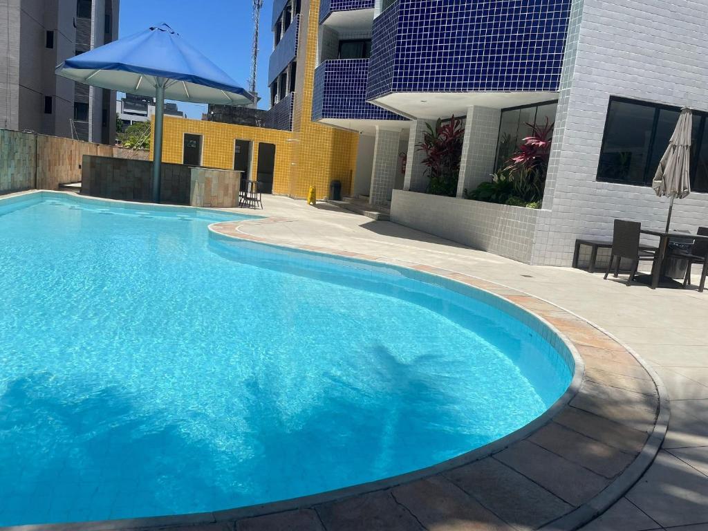 ein großer blauer Swimmingpool neben einem Gebäude in der Unterkunft Apartamento em Intermeares | Quarto Casal Estúdio in Ilha da Restinga