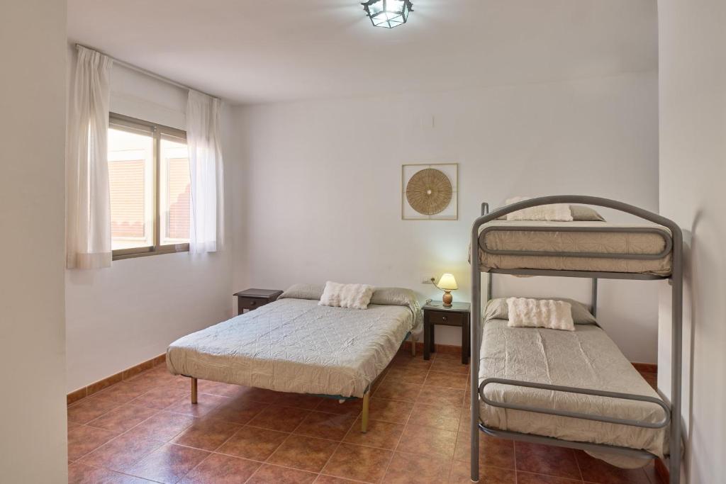 a bedroom with two bunk beds and a window at Seralva Rural Zuheros in Zuheros