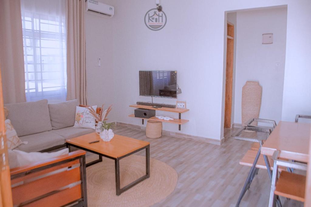 ein Wohnzimmer mit Sofa und Fernseher in der Unterkunft Kwangu Homes Dodoma Collection in Dodoma