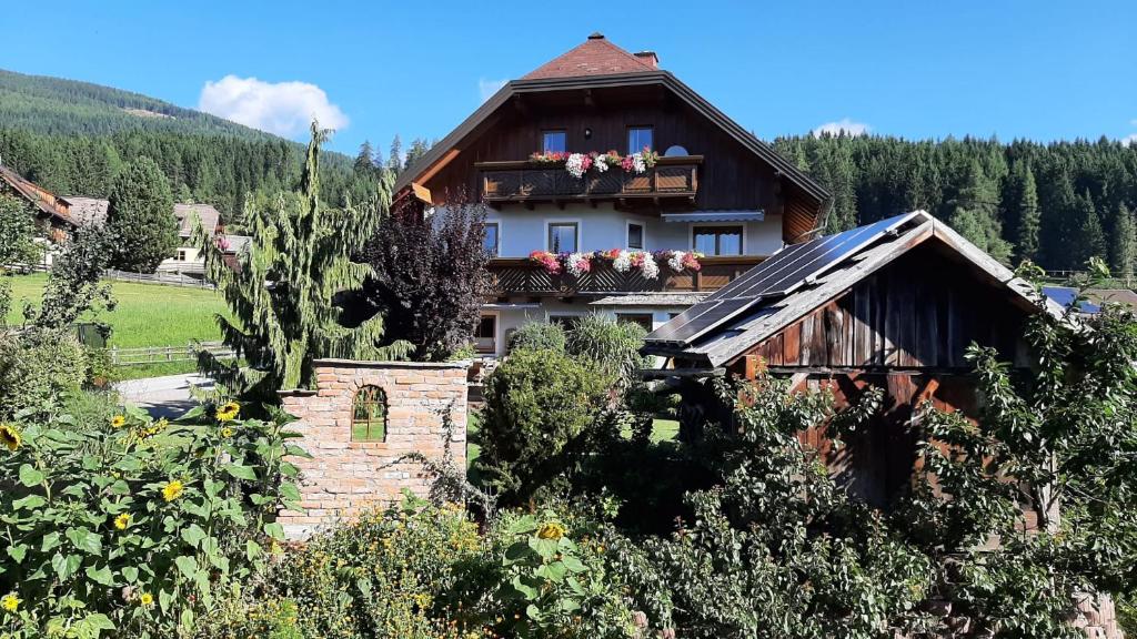 a house with a balcony with flowers on it at Ferienwohnungen Schwalbennest in Mauterndorf