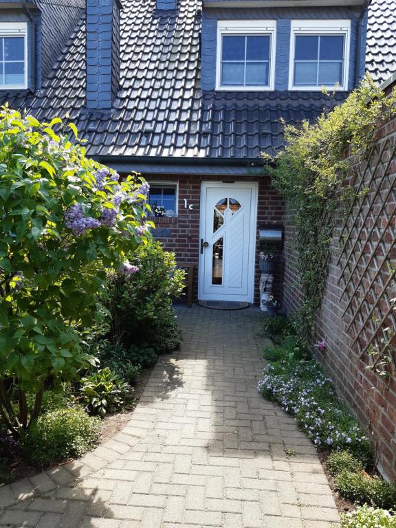 a house with a white door and a brick wall at Pension Zur Mühle in Nettetal