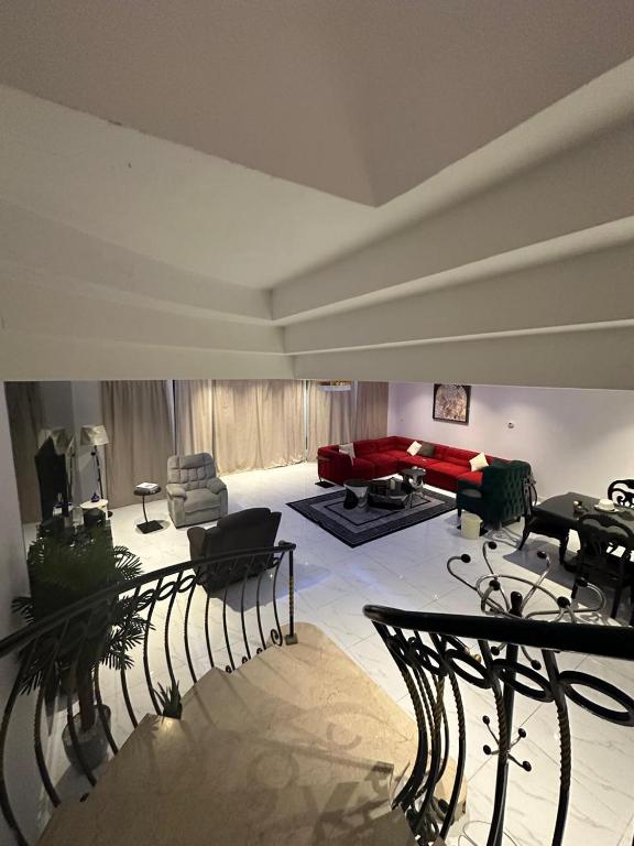 a living room with a red couch and chairs at فيلا درة العروس in Dahaban
