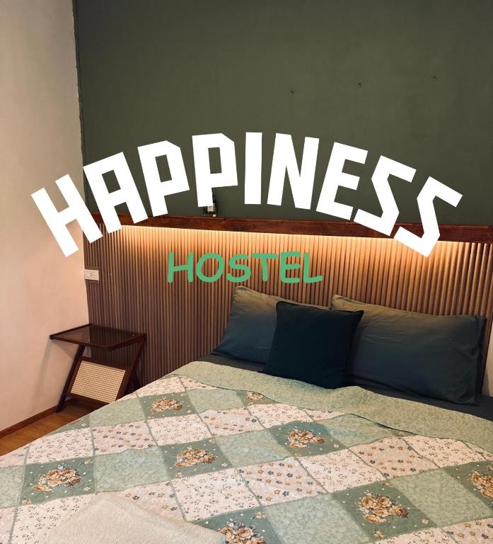 a bedroom with a bed with a sign that says happiness at Happiness Hostel Private room in Phra Ae beach