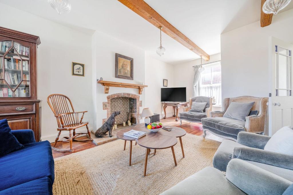 a living room with blue furniture and a fireplace at Edinburgh House in Burnham Market