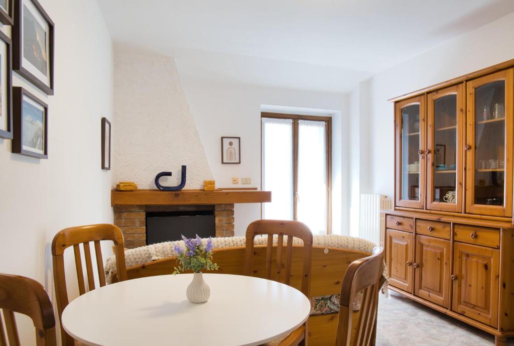 a dining room with a table and chairs and a fireplace at Lòbia in via Parrocchiale - app. Ferro P0 in Barzio