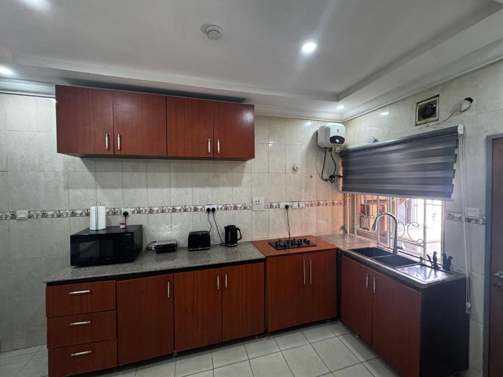 uma cozinha com armários de madeira e uma bancada em Molarans Place em Abuja