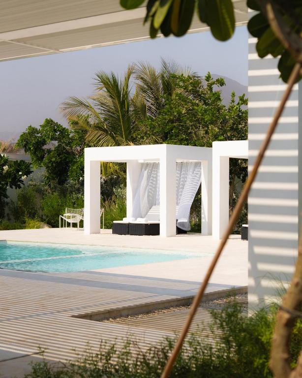 a swimming pool with a white structure next to a house at calm resort in Fujairah