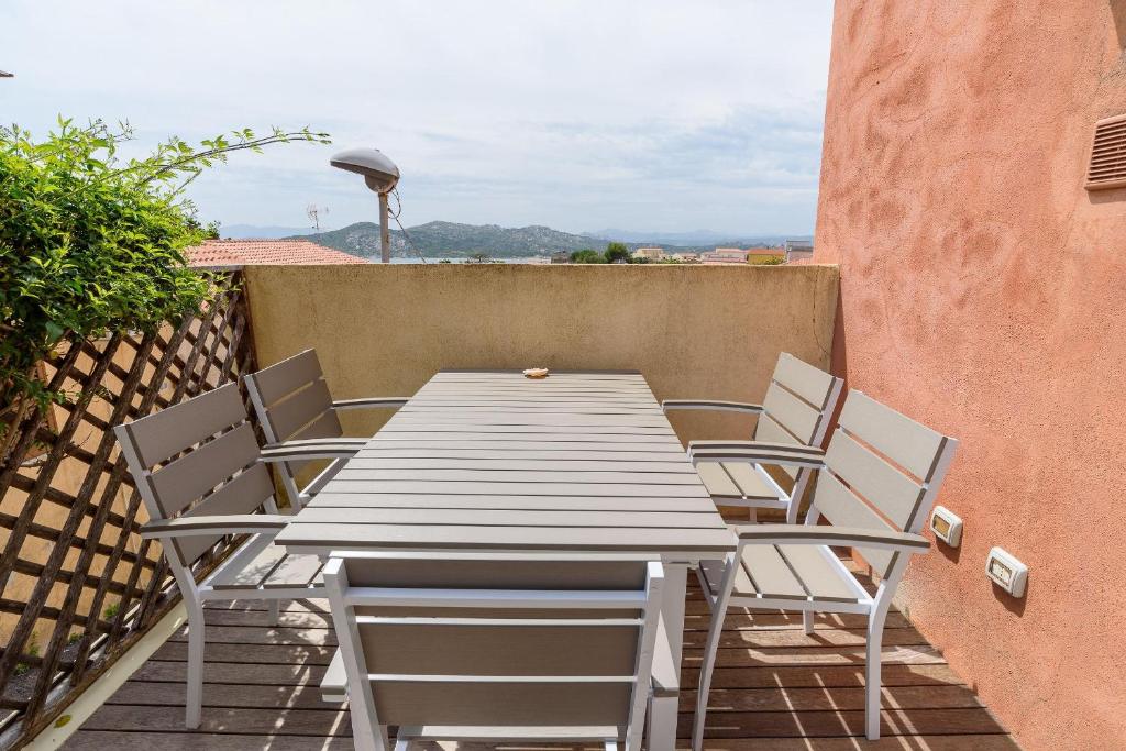 a wooden table and chairs on a balcony at Loft Kala Zèna in La Maddalena