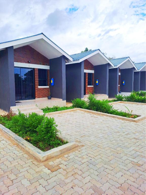 a house with blue walls and a brick driveway at Angton's Lodge in Nyanda