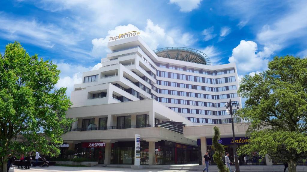 a hotel building with people walking in front of it at Z terme Harmony in Vrnjačka Banja