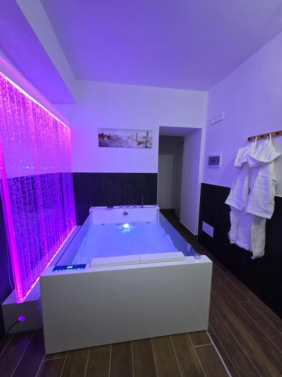 een grote badkamer met een bad met paarse verlichting bij L' Arco Rosa in Alatri