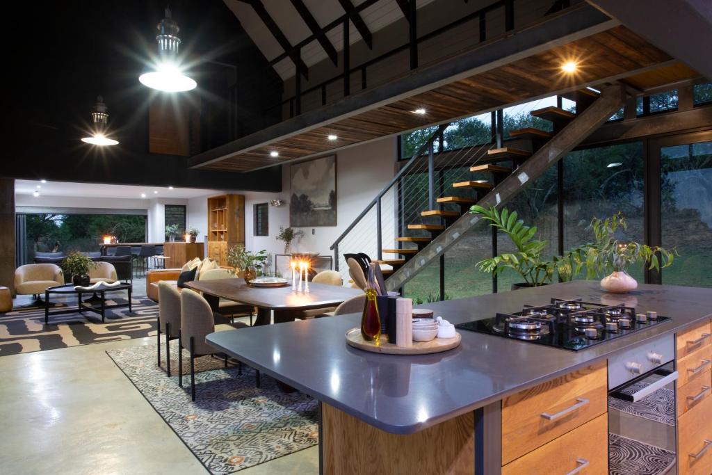 a kitchen and dining room with a stove and tables at House Nyala in Lydenburg