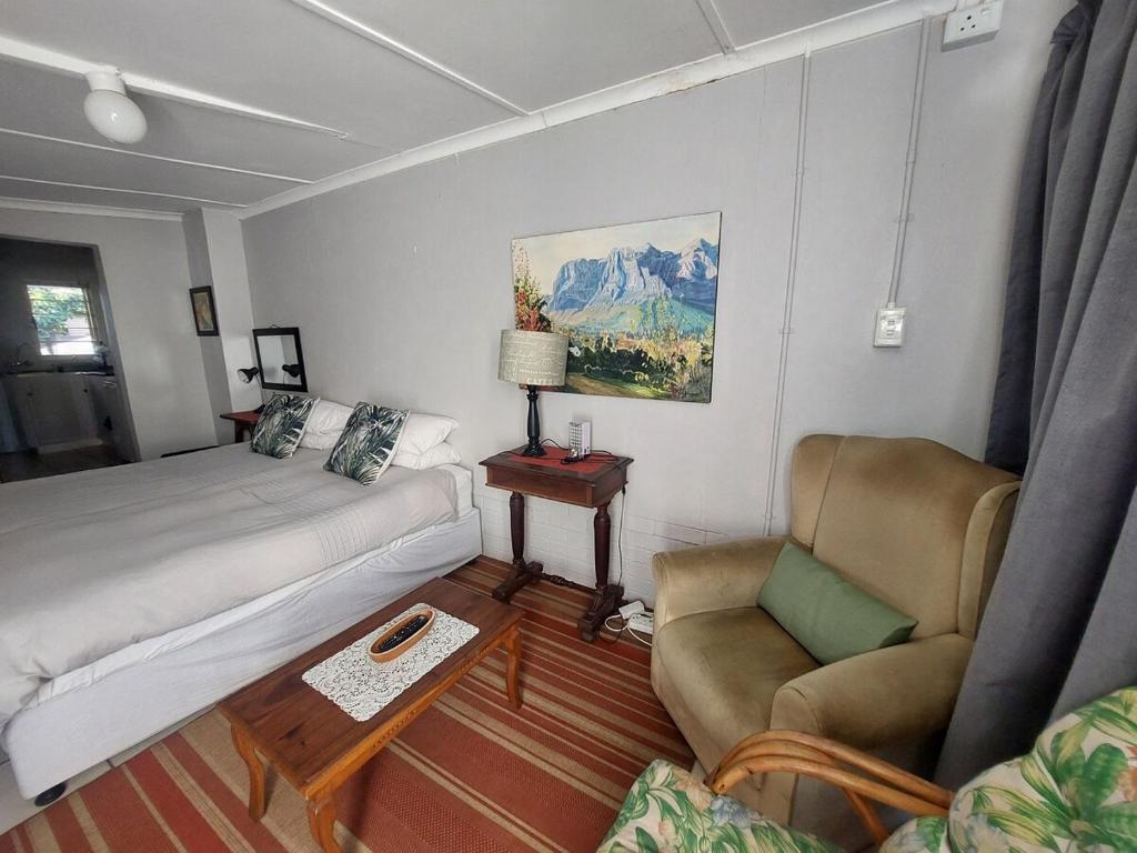 a living room with a bed and a couch and chairs at Turtle Creek - Ridleys in Umkomaas