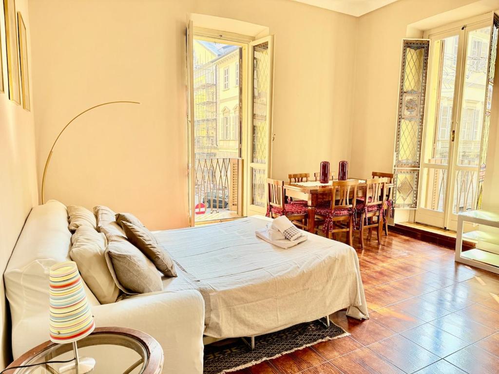 ein Wohnzimmer mit einem Bett und einem Tisch in der Unterkunft Casa Juliett royal terraces in Turin