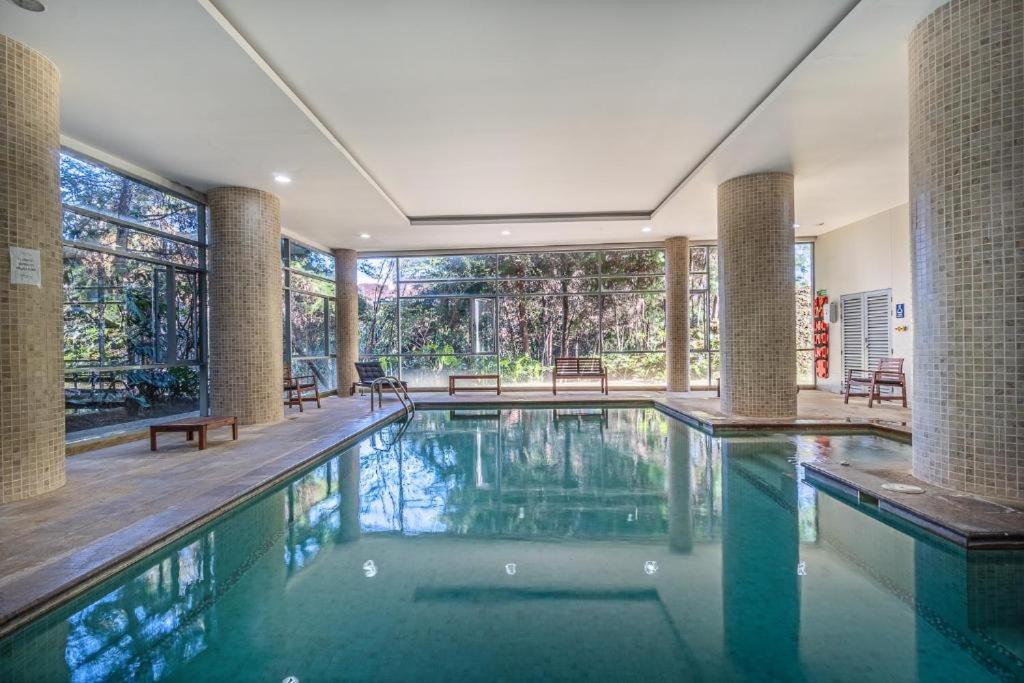 une grande piscine dans une maison avec une grande fenêtre dans l'établissement PORTANOVA SUITES - Apartamento muy cómodo, a tan sólo 5 minutos del aeropuerto JMC, à Rionegro