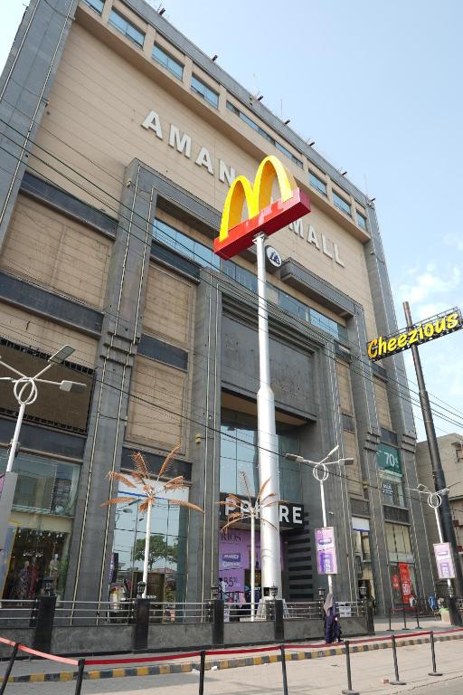 Um edifício Mcdonalds com um cartaz à frente. em Experience a New Level of Comfort in A m a n a h Mall Link Road Model Town em Lahore