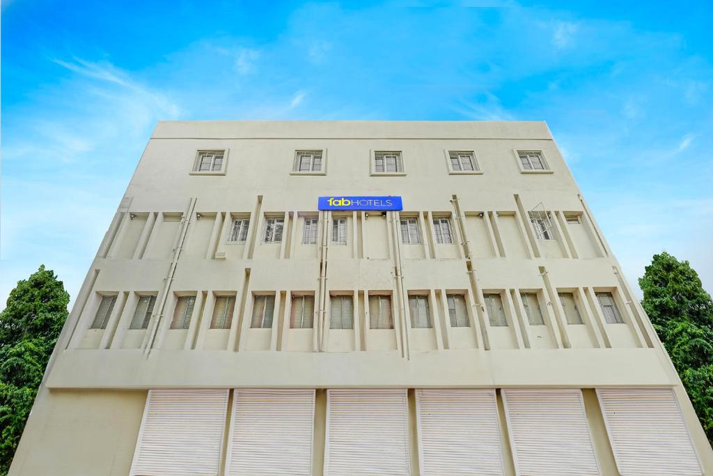 a tall white building with a blue sign on it at FabExpress Urban Inn - Yeswanthpur in Bengaluru