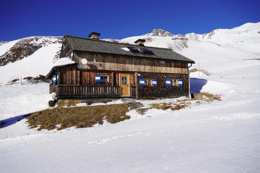 a log cabin on a snow covered mountain at Wallackhaus hütte in Untertauern