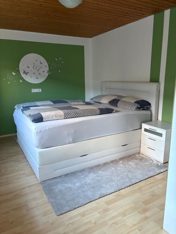 two beds in a bedroom with a green wall at LembergLodge Gosheim in Gosheim