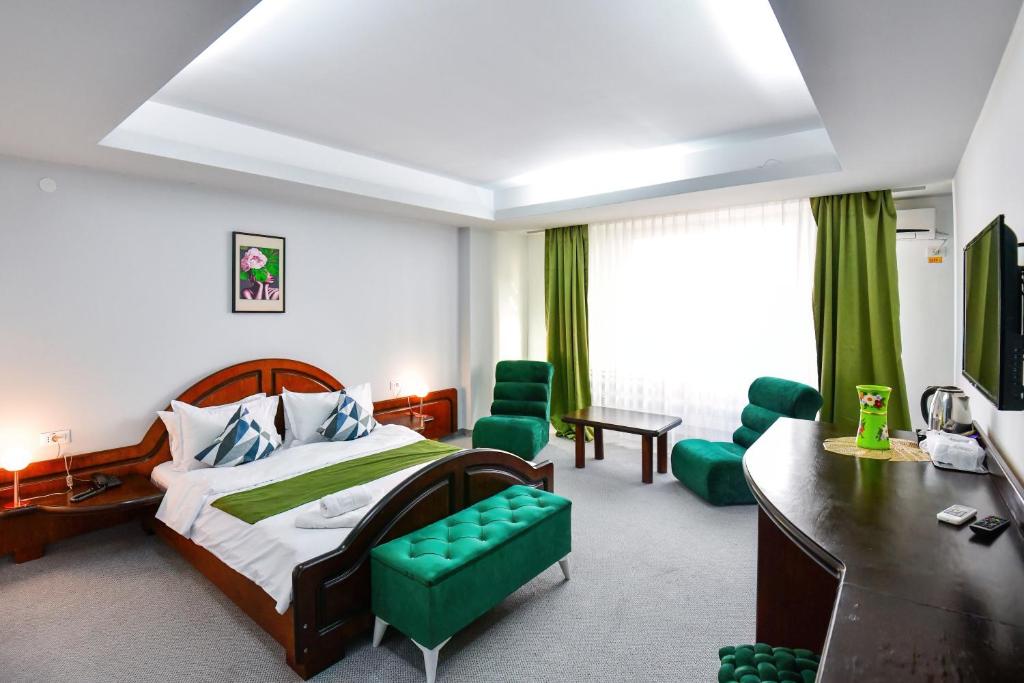 a hotel room with a bed and a desk and chairs at Royal by Euxin in Constanţa
