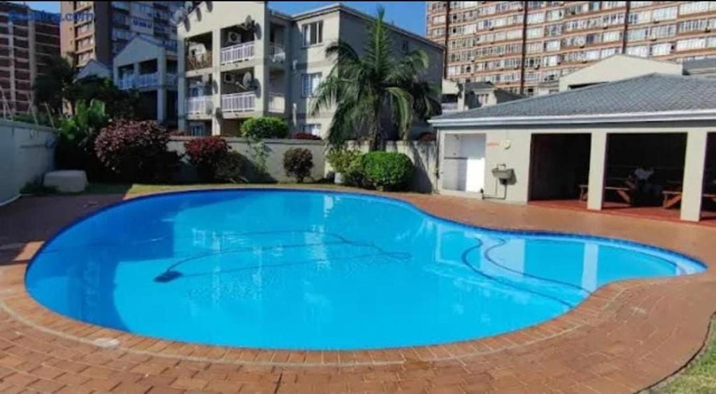 ein großer blauer Swimmingpool vor einem Gebäude in der Unterkunft Whispering Waves SummerSands in Durban