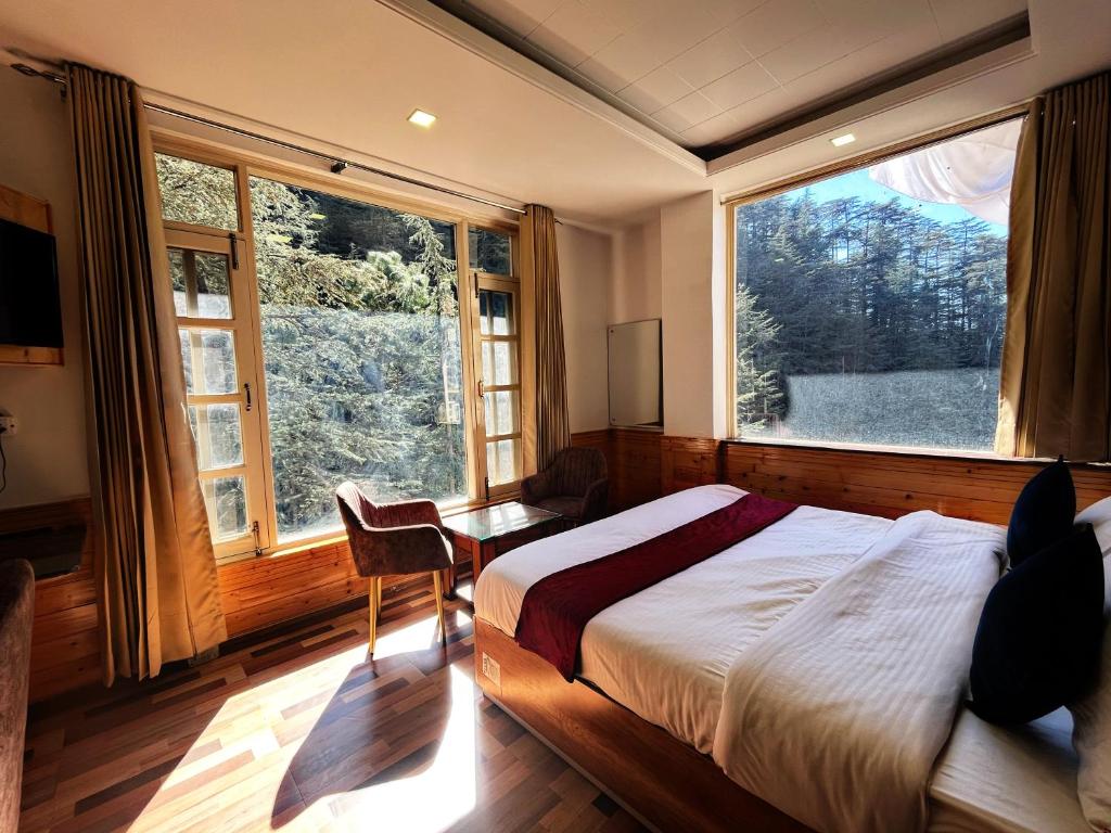 a bedroom with a bed and a large window at Decent Stays in Shimla