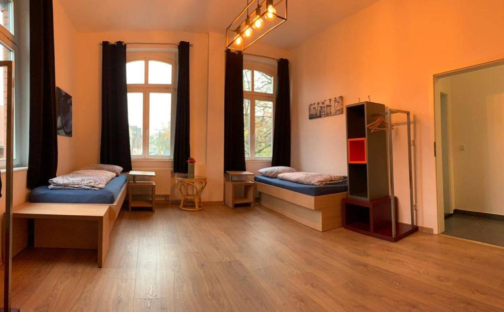 a room with two beds and two windows at Ein Zimmer in einer 4-Zimmer-Wohnung in Leipzig mit Gemeinschaftsküche und -Bad in Leipzig
