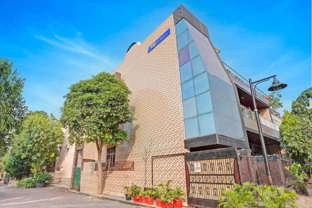 a tall brick building with a tree in front of it at FabHotel Winsome Inn in Noida