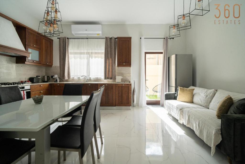a kitchen and living room with a table and a couch at A lovely 1BR studio home in Rabat with WIFI & AC by 360 Estates in Rabat