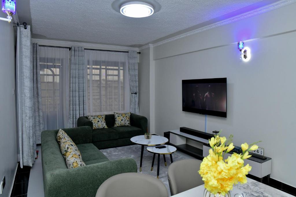 a living room with a couch and a tv at Araka Homes in Nakuru