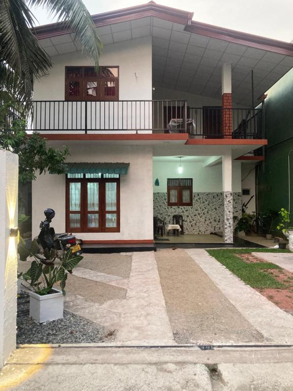 a house with a balcony on the side of it at Rhythm Transit Hotel - Near Airport in Katunayake