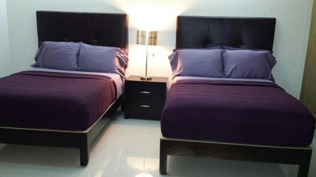 two beds sitting next to each other in a room at Premier Hotel Suites in Ciudad Obregón