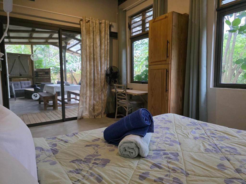 a person laying on a bed in a bedroom at Le Pavillon, at La Petite Ferme 2BRoom with private fireplace in Grand Sable