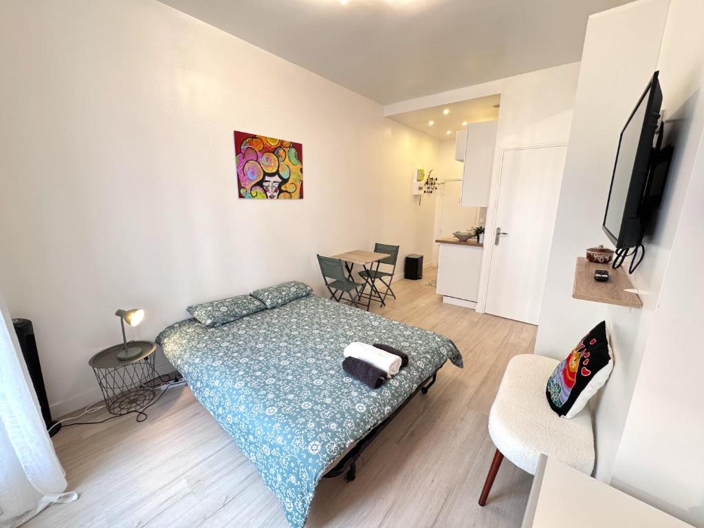ein Schlafzimmer mit einem Bett und einem Fernseher in der Unterkunft Hyper Centre de Vincennes - Métro 3 min in Vincennes