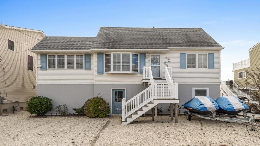 a house with two boats parked in front of it at Lagoon Front 4 Bedroom Beat The Crowds in Beach Haven West