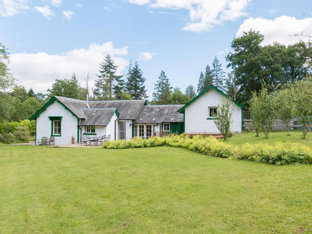 ein Haus mit einem großen Garten davor in der Unterkunft Grace's Cottage in Port of Menteith
