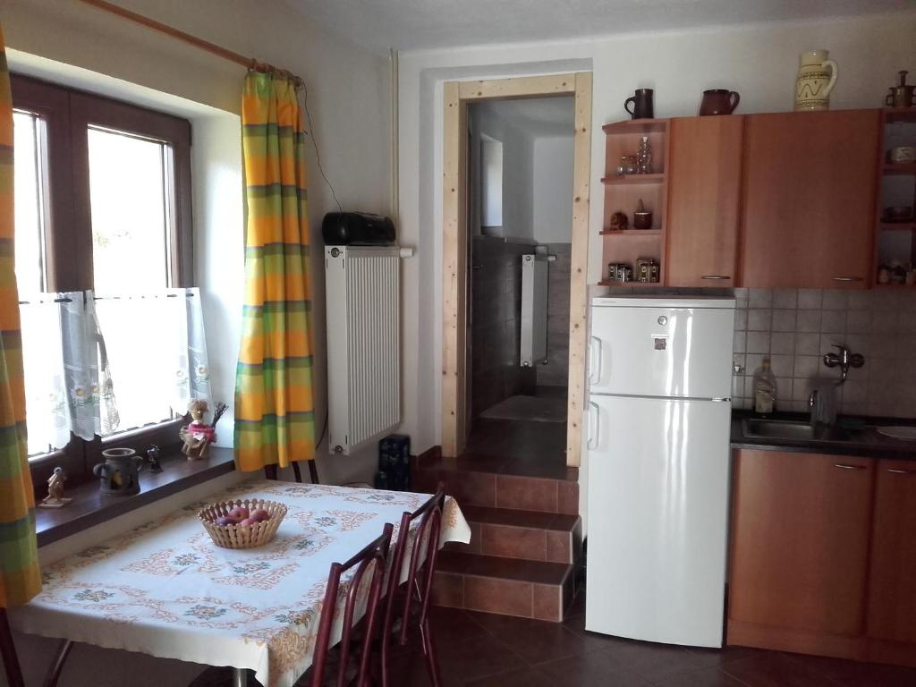 a kitchen with a table and a white refrigerator at Chalupa Aja in Čierny Blh