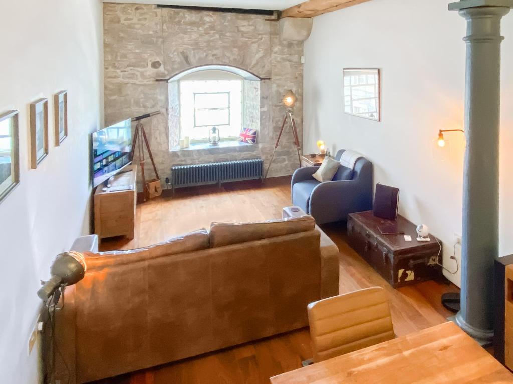 a living room with a couch and a tv at The Sail Loft - Royal William Yard in Millbrook