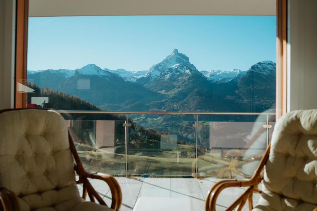 two chairs in front of a window with a mountain view at Apartment Elona in Amden