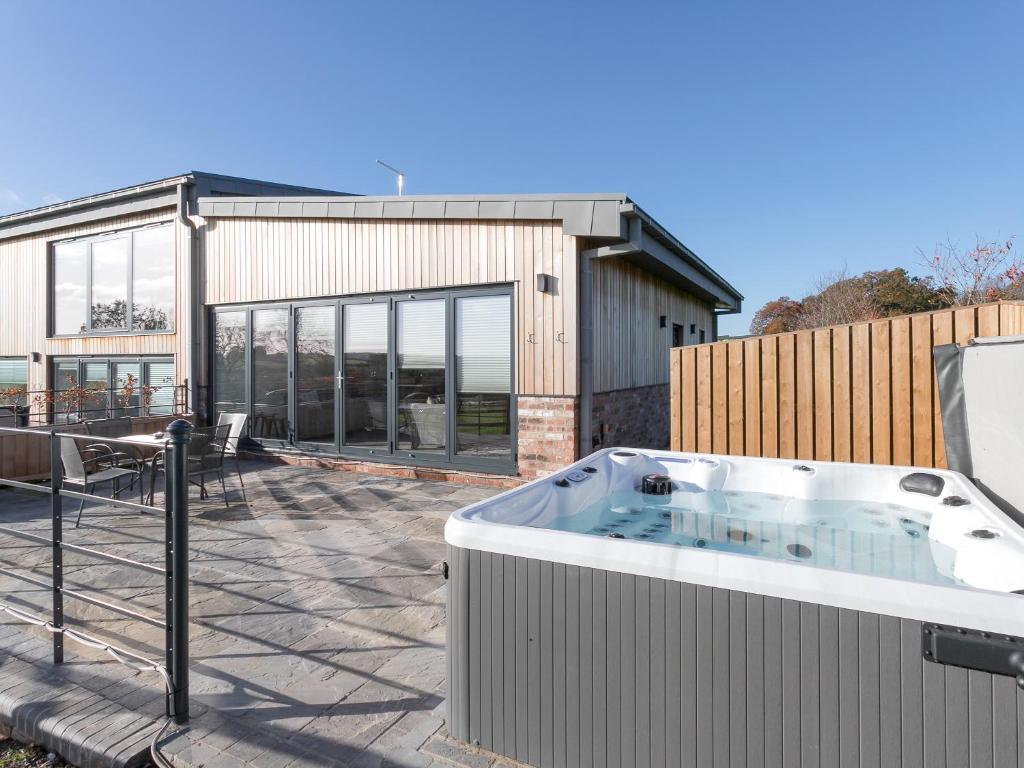 einen Whirlpool auf einer Terrasse mit einem Gebäude in der Unterkunft The Hideaway -Ukc3844 in Ticknall