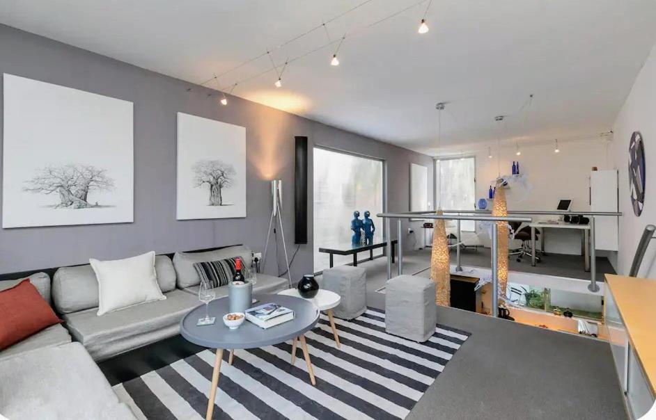 una sala de estar con un sofá y una mesa en Modern designer loft with solar, en Honeydew